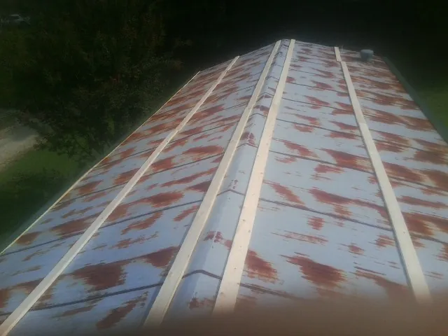 Rusted metal roof panels with new wood purlins before replacement — Storm Damage Roof Repair in Newtonsville by Roofing Brothers