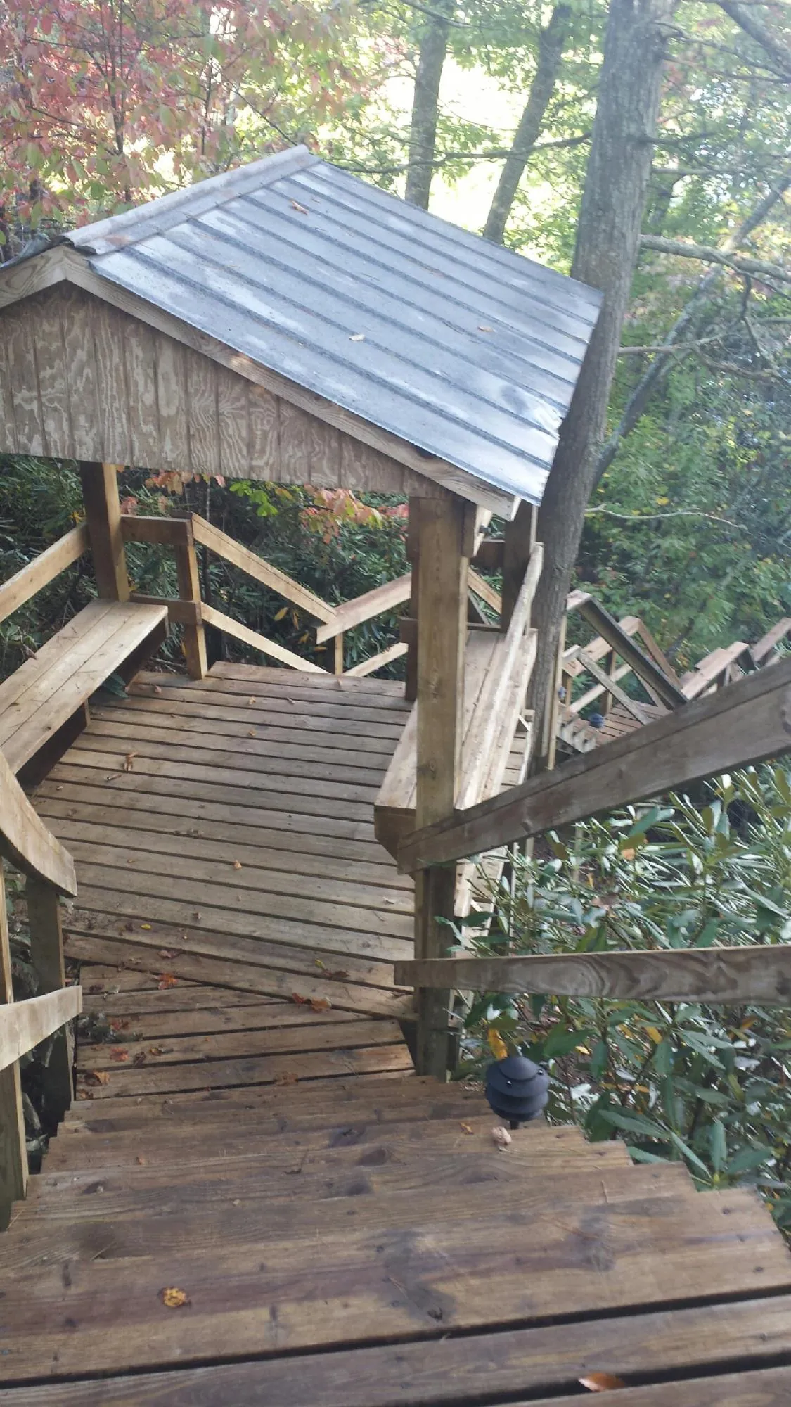 Metal roofed shelter over wooden steps on a wooded walkway — Skylight Repair & Installation work by our crew in Newtonsville