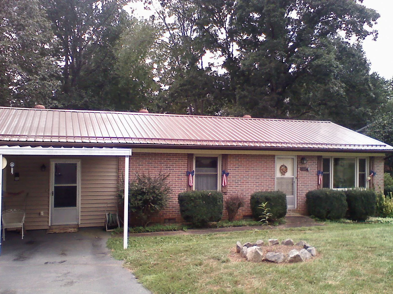 Bronze metal roof and carport on a brick ranch home — Roof Repair work by our crew in Newtonsville